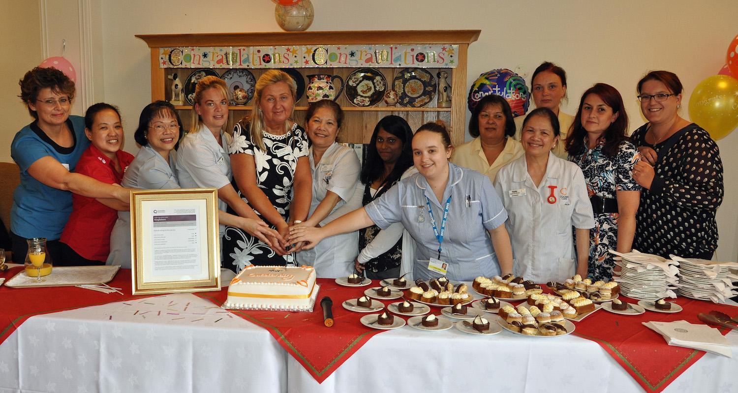 Beata Brzozowska, Home Manager, Colten Care's Kingfishers in New Milton celebrates the CQC Outstanding rating with fellow staff.