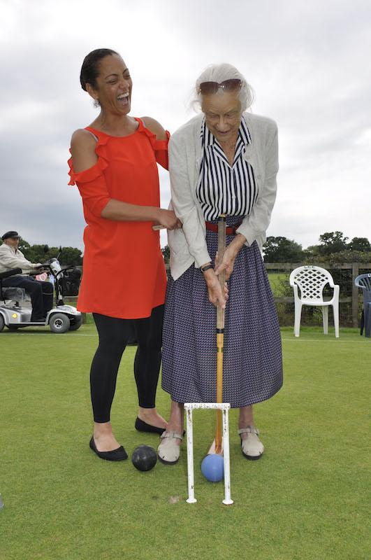 Court Lodge resident Eileen Simpson swings her mallet accompanied by Home Manager Sam Reid.