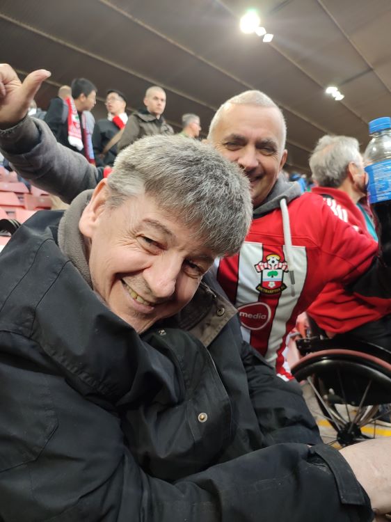 Two gentlemen one in Saints kit enjoying St Marys Football Stadium Southampton